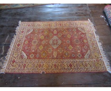 An eastern wool rug with red ground field central medallion and floral detail, within alternating repeating running borders, 