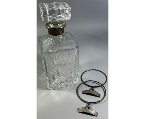 A glass decanter with silver collar and two silver drink labels unmarked 