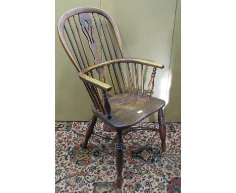 An early 19th century Windsor comb back elbow chair with pierced splat and crinoline stretcher in ash and elm 