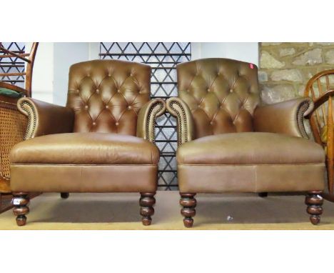 A pair of contemporary Victorian style tan leather upholstered easy chairs with button backs and turned supports 