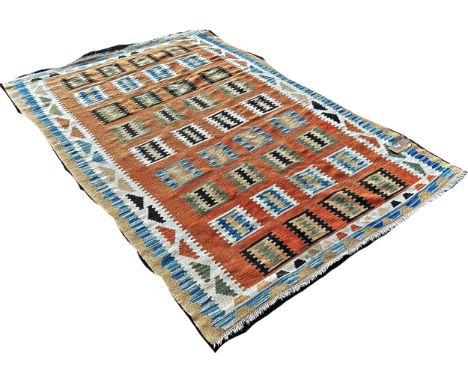 A Kilim rug with abstract tribal patterns on a peach ground, 230cm x 150cm approximately