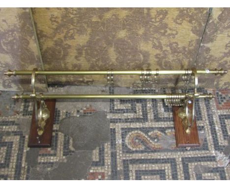 A cast brass wall mounted double coat rail with decorative open scrolled bracket, mounted on rectangular moulded wooden plaqu