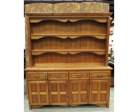 A large pine kitchen dresser, the base enclosed by four panelled doors and four frieze drawers beneath a recessed open plate 