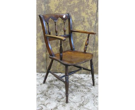 A Windsor elm and beechwood open armchair with turned spindle back over a saddle shaped seat 