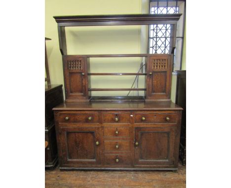 An early 19th century north Welsh dresser the base enclosing a T shaped arrangement of drawers (three dummy) enclosed by two 