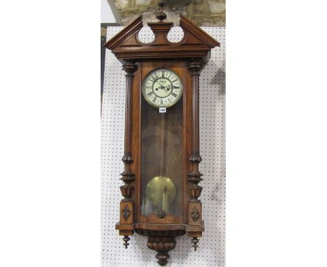 A 19th century Vienna regulator wall clock in a walnut case of architectural form, with twin weight driven movement.