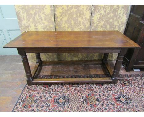 An old English style refectory table in the Cromwellian manner raised on four gun barrel supports, 184cm long x 78cm wide