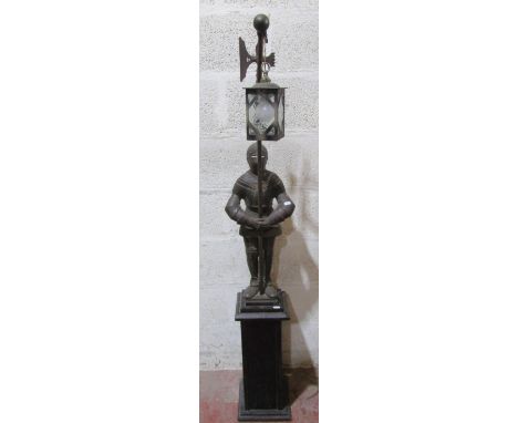 A lamp standard formed by a knight in armour, supported on a square cut oak frame, 155cm high