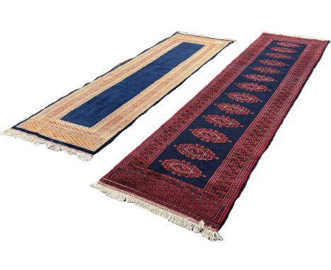 A Kashmiri runner with a central row of connected medallions on a dark blue ground 325cm x 80cm approximately, together with 