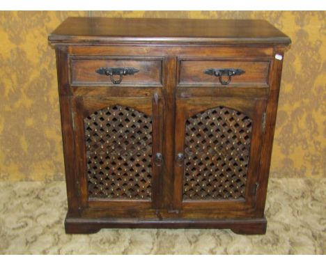 A small Indian hardwood dresser enclosed by a pair of arched lattice panelled doors beneath two frieze drawers 88 cm high x 9