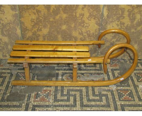 A vintage beechwood toboggan with slatted seat, 36 cm high x 100 cm long (af)
