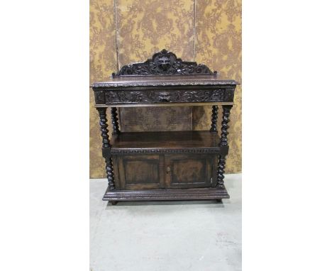 A Victorian oak buffet with carved lions mask, scrolling acanthus and further detail incorporating a frieze drawer and cupboa