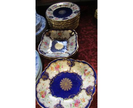 An Aynsley dessert service, richly decorated with floral panels within blue and gilt reserves, 16 plates and four shaped dish