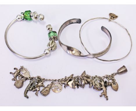 A silver charm bracelet, a silver CHAM bangle and two others.