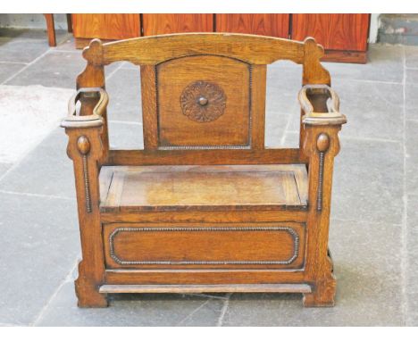 A 1920s oak bench with chest base and stick stand sides. W90cm D34cm H89cm.