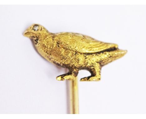 A yellow metal hat pin the guinea fowl finial with diamond eye, length 6cm, wt. 1.9g.