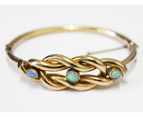 A Victorian 9ct gold bangle set with three opals, diam. 6cm, gross wt. 9.2g.