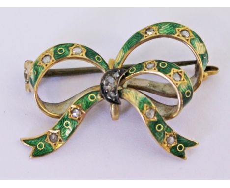 A yellow metal diamond and green enamel brooch formed as a bow, stamped '417', length 3.5cm, gross wt. 4.6g.