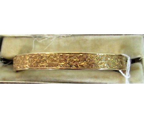 A cased 9 carat gold hinged bangle with engraved floral decoration.  Condition Report: 10 grams.