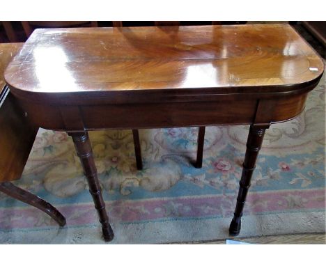 A Victorian mahogany fold-over card table on ring turned supports.