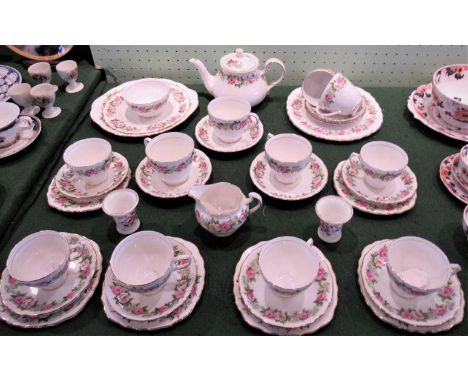 A Colclough tea service with pink and green floral decoration on a white ground comprising: six trios, teapot, sugar bowl, mi