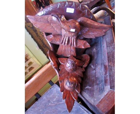 An early 20th century carved corner shelf in the form of an eagle.