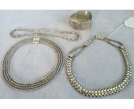 A multi strand snake link silver choker, together with two further silver link chokers and a segmented bangle with Far Easter