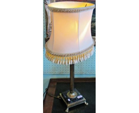 A contemporary brass and marble table lamp with tasselled shade.