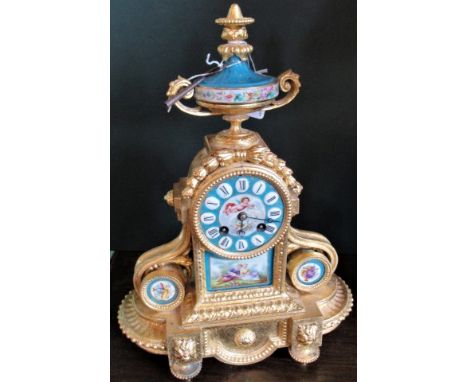 A 19th century ormolu mantle clock, having twin handled and ceramic urn surmount, above a decorated enamel face with Roman nu