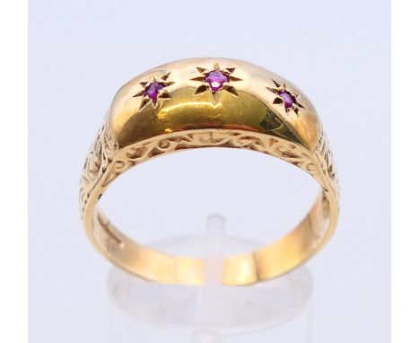 A 9 ct gold three stone ruby ring.  Ring size Y.