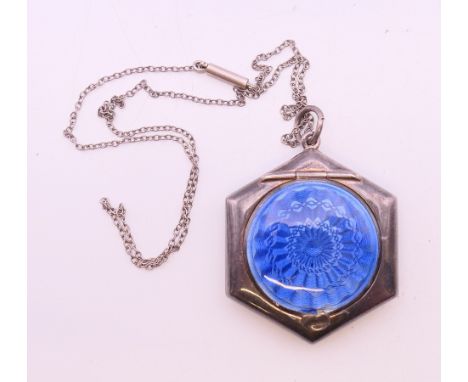 A silver and enamel fob compact on a chain. 3.5 cm wide.