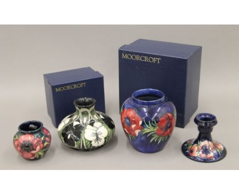 Three Moorcroft pottery vases and a Moorcroft pottery candlestick. The largest 12 cm high.