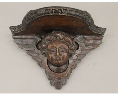 A 19th century carved oak wall bracket formed as a cherub. 36 cm wide. 