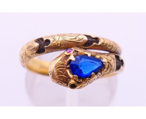 An antique unmarked gold ruby and sapphire snake form mourning ring, the interior set with hair plait. Ring size N/O. 