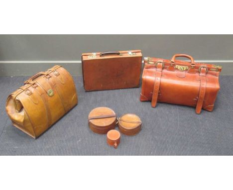 A leather gladstone bag and two leather briefcases and three small collar boxes.The briefcase has watermarks and stainign to 