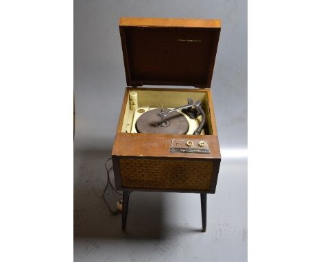 A PHILCO VINTAGE RECORD PLAYER ON LEGS, constructed from a walnut veneer over plywood with tapered round legs finished on bra