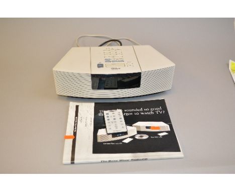 A BOSE WAVE RADIO/CD PLAYER, in white, model No.AWRC3P, Serial No.023077311990013AC, with white faced remote control and manu