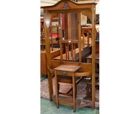 A 1930/40's oak hall stand, arched pediment over bevel edge mirror and hooks to top, single drawer flanked by stick stands to