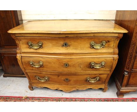 Antique Continental fruitwood bombe shaped commode chest, the moulded top above three long drawers with heavy brass handles r