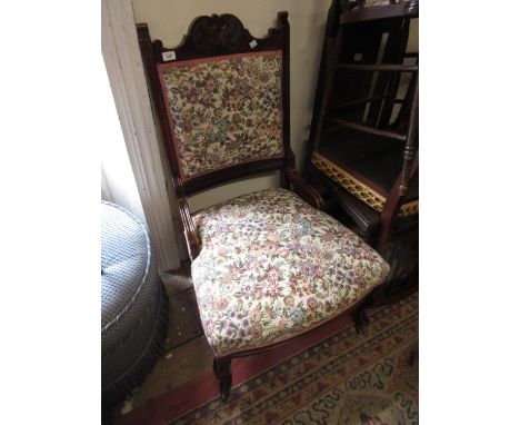 Art Nouveau mahogany low seat side chair and matching armchair with floral upholstery, the supports with casters and an oval 