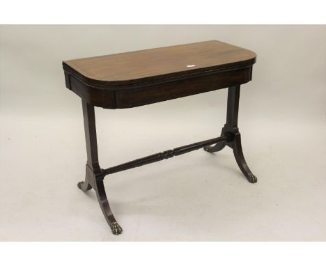 George IV mahogany and black line inlaid D-shaped fold-over card table, raised on rectangular cut end supports above a turned