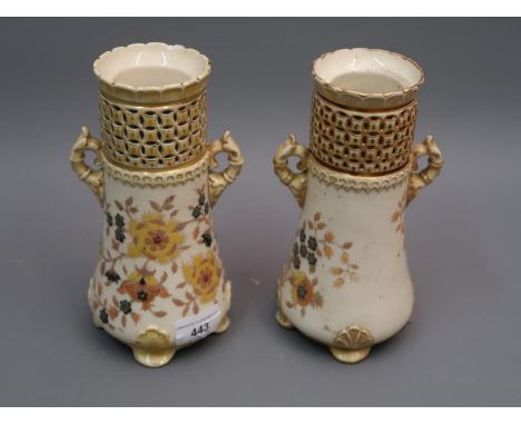 Pair of Zsolnay Pecs vases of two handled tapering design, decorated with flowers on a cream ground beneath reticulated necks