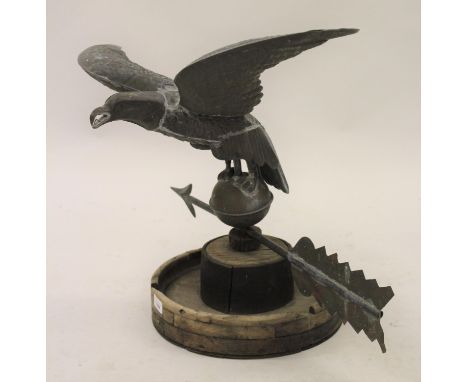 Elm, brass and iron weather vane in the form of an eagle with outstretched wings above an arrow and circular base, 23ins high