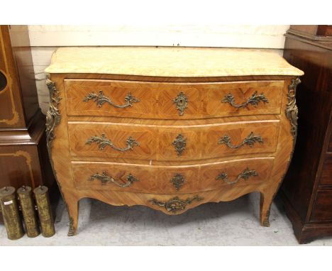 20th Century Continental Kingwood bombe commode, the veined beige marble top above three drawers with rococo design patinated