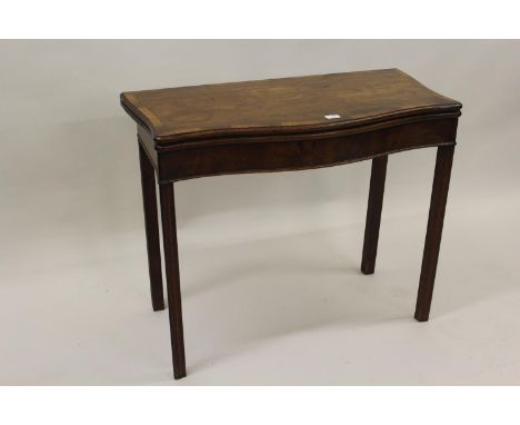 George III mahogany crossbanded and line inlaid serpentine fronted card table with a fold-over top, enclosing a baize lined i