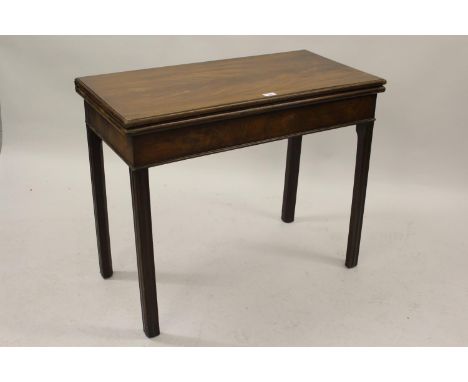 George III mahogany rectangular fold-over card table with a plain frieze and four square cut chamfered and moulded supports, 