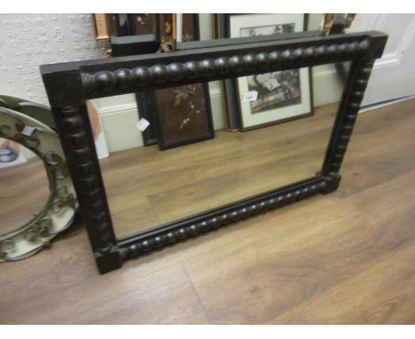 Early 20th Century ebonised rectangular wall mirror with bobbin decorated frame, 32ins x 20ins 
