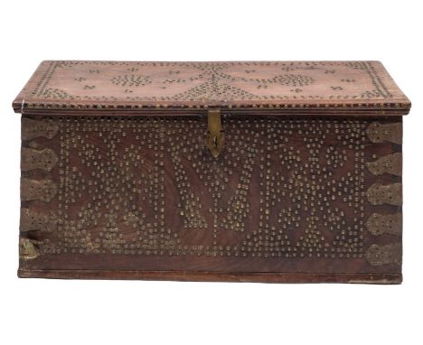 A 19th-century Zanzibar hardwood and brass studded trunk; with a hinged top enclosing a candle box, with all-over geometric d