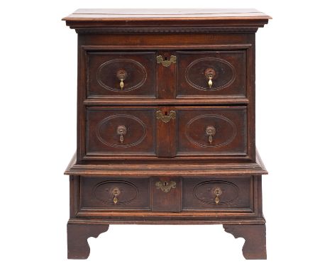 An oak chest in the Jacobean style, in two sections, 17th-century and later; with an overhanging moulded top, with three long
