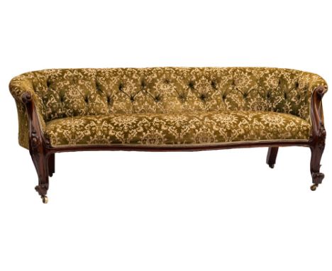 A Victorian carved walnut and upholstered sofa, circa 1870; with buttoned green velvet damask coverings; the arm fascias carv